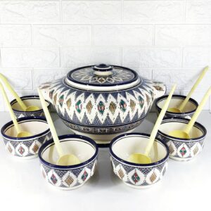 Soupière artisanale en porcelaine 12 piècesRamadan en porcelaine blanche avec bord doré, 12 bols assortis et 6 sets de table blancs avec motif floral bleu et doré. La table est dressée pour un repas de Ramadan.